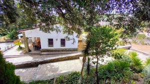 una pequeña casa blanca en medio de un jardín en Villa Victoria Nº30, en Santa María de Trassierra