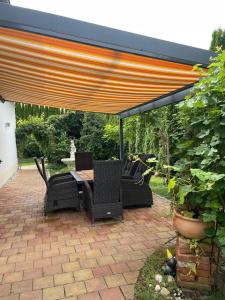 een patio met een tafel en stoelen onder een parasol bij Luxury Apartment near Munich Airport - Therme ED - Parking in Berglern