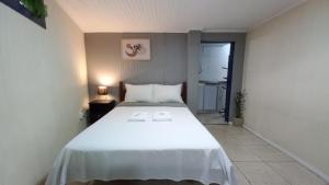 um quarto com uma grande cama branca num quarto em Suíte Aconchegante em Hospedaria no Centro em Ouro Preto