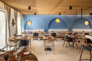 un ristorante con tavoli e sedie in legno e pareti blu di Emotheo Heritage Hotel a Imotski (Imoschi)