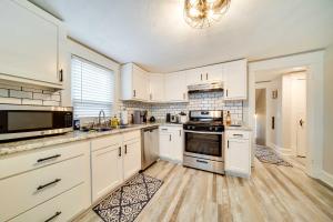 a kitchen with white cabinets and a stove top oven at Meadville Apartment with Deck Less Than 2 Mi to Allegheny! in Meadville