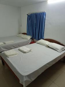 two beds in a room with blue curtains at Good Luck Hostel in Phnom Penh