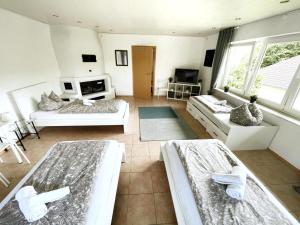 a large room with three beds and a couch at Pension Platzhirsch in Mücke