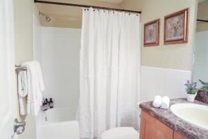 拉哥Sunnyside Palms - 2BR, Poolside, 5 min to Beach的浴室设有白色的淋浴帘和水槽