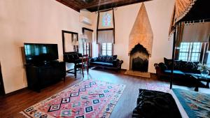 Una sala de estar con chimenea y televisión. en Otantik Hotel & Spa, en Bursa