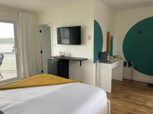 Schlafzimmer mit einem Bett und einem Flachbild-TV in der Unterkunft The Marmalade Motel in Port Dufferin