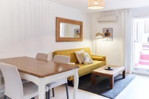 a living room with a yellow couch and a table at HA Diputació terrace apartment in Barcelona