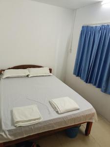 Bett in einem Zimmer mit blauem Fenster in der Unterkunft Good Luck Hostel in Phnom Penh