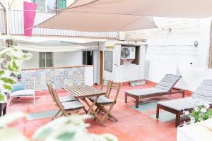 patio z krzesłami, stołem i parasolem w obiekcie HA Diputació terrace apartment w Barcelonie