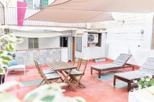 a patio with chairs and a table and an umbrella at HA Diputació terrace apartment in Barcelona