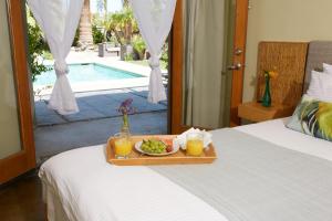 ein Tablett mit Essen auf einem Bett mit einem Teller. in der Unterkunft The Spring Resort & Spa in Desert Hot Springs