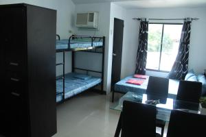 a room with two bunk beds and a table at Large New Studio Up to 6 Pax in Cebu City