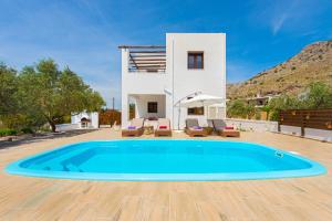 a villa with a swimming pool in front of a house at Melfe Villas in Pefki