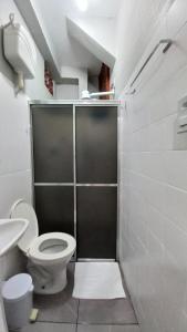 a bathroom with a toilet and a shower stall at Suíte Charmosa em Hospedaria no Centro in Ouro Preto