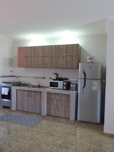 a kitchen with wooden cabinets and a refrigerator at Departamento Confortable in Puerto Iguazú