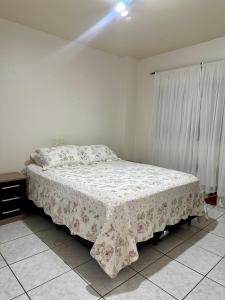 1 dormitorio con 1 cama con mesa y ventana en Apartamento no Centro Foz do Iguaçu 130 mt, en Foz do Iguaçu