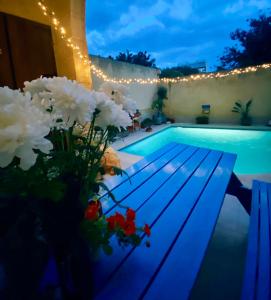 a swimming pool with flowers and lights next to it at Encanto Vegetarian Bed & Breakfast in Xagħra