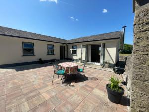 a patio with a table and chairs and a house at The Potters Lodge in Carrick on Shannon