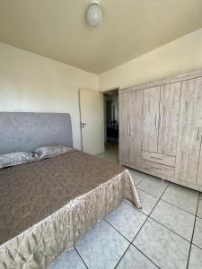 1 dormitorio con 1 cama y armarios de madera en Apartamento no Centro Foz do Iguaçu 130 mt, en Foz do Iguaçu