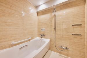 a bathroom with a bath tub and a shower at Richmond Hotel Nagasaki Shianbashi in Nagasaki
