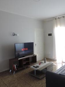 - un salon avec une télévision et une table basse dans l'établissement Departamento Confortable, à Puerto Iguazú