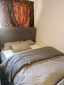 Una cama en una habitación con una cortina. en D Merciful Homes, en Kent