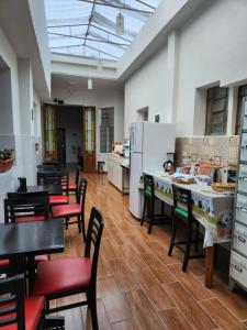 a large kitchen with tables and chairs and white appliances at Fujima Hostel in São Paulo