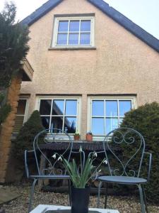 two chairs sitting in front of a house at Annexe Lodge cottage in Drymen in Drymen