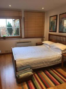 1 dormitorio con 1 cama grande y 2 ventanas en Annexe Lodge cottage in Drymen, en Drymen