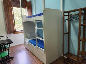 Zimmer mit einem Etagenbett und einem Tisch in der Unterkunft Fujima Hostel in São Paulo