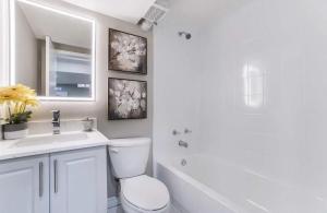 Baño blanco con aseo y lavamanos en Luxury homestay in Mississauga near square one mall & Pearson Airport en Mississauga