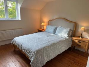 sypialnia z łóżkiem z niebieską kołdrą i 2 lampami w obiekcie The Old Coach House w mieście Stratford-upon-Avon