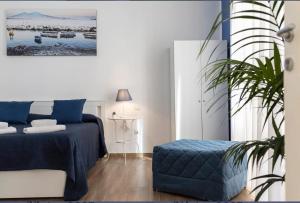 Un dormitorio con una cama azul y una planta en Spaccanapoli Rooms Duomo, en Nápoles