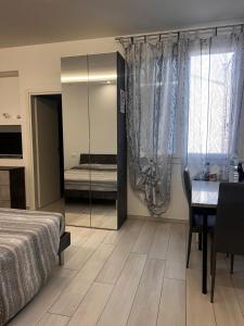 1 dormitorio con cama, mesa y espejo en RoomsCarli en Comacchio
