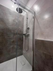y baño con ducha y puerta de cristal. en RoomsCarli en Comacchio