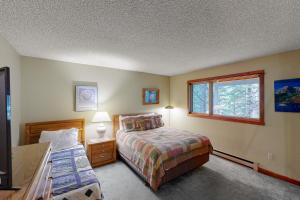 a bedroom with a bed and a window at Hidden Village 20 in Big Sky