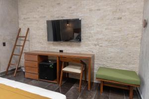 a room with a desk with a tv and two chairs at Hotel Sun Ha Bacalar in Bacalar