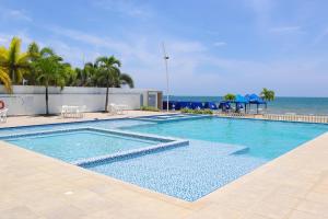 ein Swimmingpool mit dem Meer im Hintergrund in der Unterkunft Mágico Apartamento Frente al Mar 3 Habitaciones PV82 in Coveñas