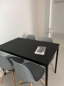 une table noire avec deux chaises et un papier sur elle dans l'établissement Lumbini Home, à Palaiseau