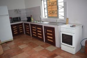 a kitchen with a white stove and a sink at Villa Duplex à Arconville in Cotonou
