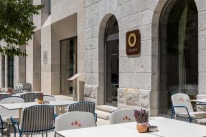 a group of tables and chairs in front of a building at Emotheo Heritage Hotel in Imotski