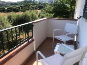 托爾托雷托的住宿－Casa Vacanze 365 - blu，阳台配有白色椅子,享有乡村美景。