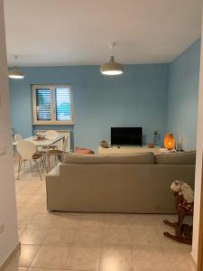 ein Wohnzimmer mit einem Sofa und einem Tisch in der Unterkunft Casa Vacanze 365 - blu in Tortoreto Lido