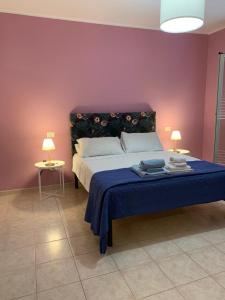 Casa Vacanze 365 - blu في تورتوريتو ليدو: غرفة نوم بسرير وبطانية زرقاء ومصباحين
