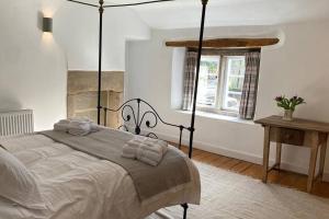 1 dormitorio con cama y ventana en Bridgefoot Cottage en Froggatt