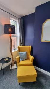 a living room with a yellow chair and a table at En Suite room with kitchen facilities in Nottingham