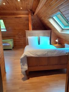 1 dormitorio con 1 cama en una cabaña de madera en Au bord de l'Orléans en Spa