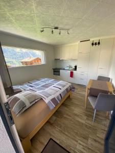 a bedroom with a bed and a table in it at Aux Grands-Vergers in Bruson