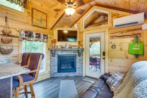a living room with a fireplace in a log cabin at 7 Mi to Lake Lure Mill Spring Cabin with Hot Tub in Mill Spring
