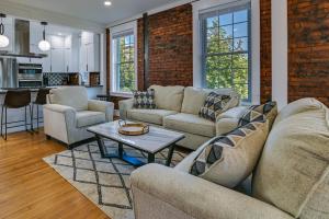 sala de estar con sofás y pared de ladrillo en Contemporary Cohoes Retreat with Electric Fireplace!, en Cohoes